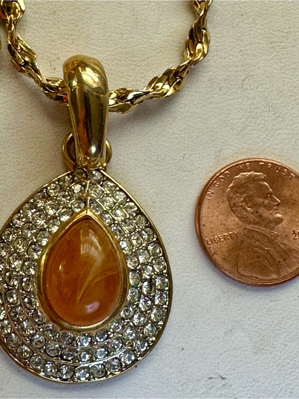 Gold Teardrop Pendant on a 36” Necklace with Amber Center and Crystal Halo
